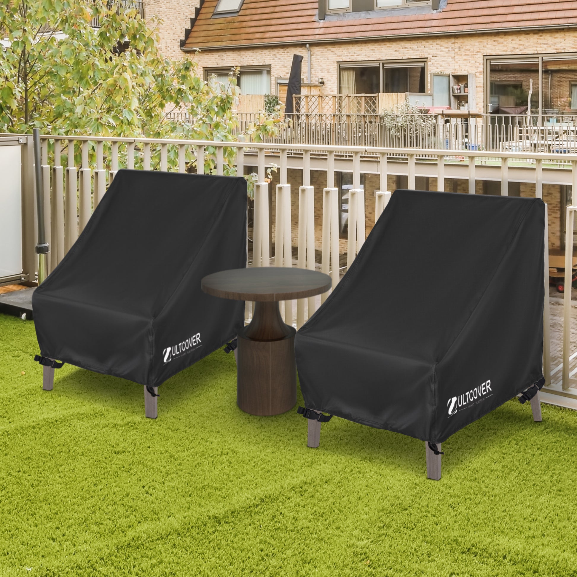 Two black outdoor furniture covers on chairs with a table in a backyard setting. black