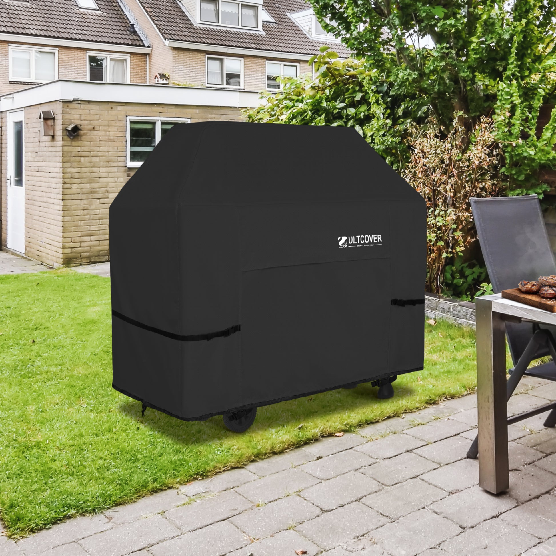 Black grill cover on a patio with a house and garden in the background black